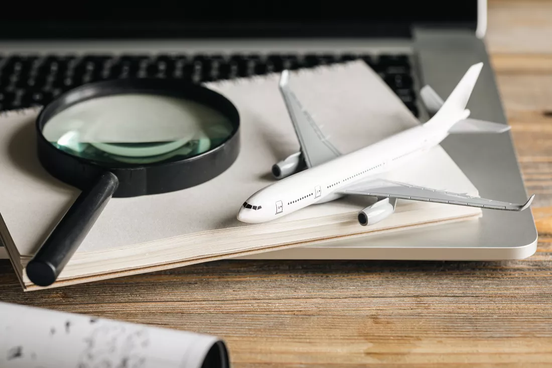 travel-composition-with-airplane-magnifying-glass-map-wooden-table